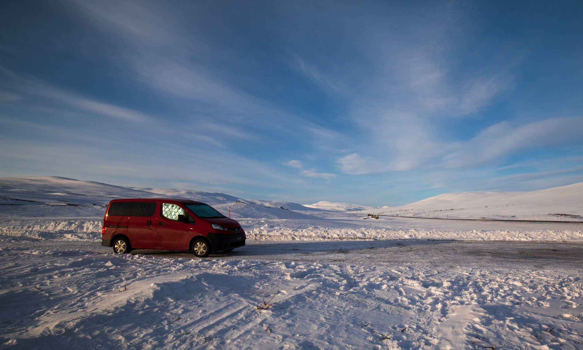Roter Campervan (Trotti BrumBrum) auf Parkplatz am Polarkreis in Norwegen